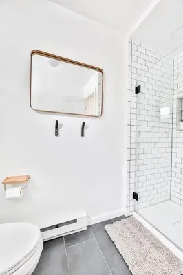 a white bathroom with a mirror and a toilet at Cozy Winter Retreat Minutes from Hunter Mountain in Jewett