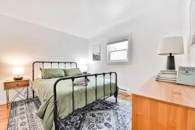 a bedroom with a bed and a table with a lamp at Cozy Winter Retreat Minutes from Hunter Mountain in Jewett