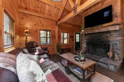 a living room with a couch and a fireplace at Cozy Log Cabin with Hot Tub 10 Min to Hunter Mtn in Jewett