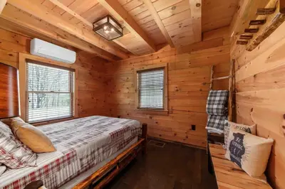 a bedroom with a bed in a log cabin at Cozy Log Cabin with Hot Tub 10 Min to Hunter Mtn in Jewett