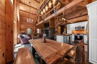 a large kitchen with a wooden table in a cabin at Cozy Log Cabin with Hot Tub 10 Min to Hunter Mtn in Jewett