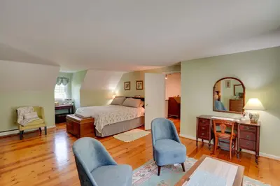 a bedroom with a bed and a desk and chairs at Cozy Pittsfield Gem with Deck, Gazebo and Fireplace in Pittsfield