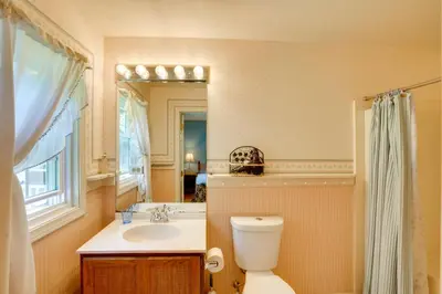 a bathroom with a toilet and a sink and a mirror at Cozy Pittsfield Gem with Deck, Gazebo and Fireplace in Pittsfield