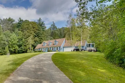 a house with a truck parked in the driveway at Cozy Pittsfield Gem with Deck, Gazebo and Fireplace in Pittsfield