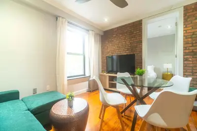 a living room with a green couch and a table at New2 York Stylish 2BR Apartment in Manhattan in New York
