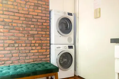 a washer and dryer next to a brick wall at New2 York Stylish 2BR Apartment in Manhattan in New York