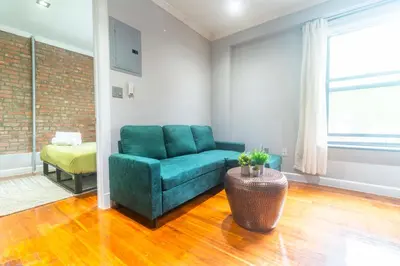 a living room with a green couch and a table at New2 York Stylish 2BR Apartment in Manhattan in New York