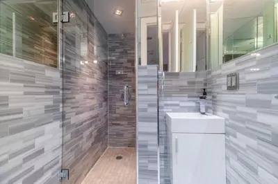a bathroom with a shower and a sink and a mirror at New2 York Stylish 2BR Apartment in Manhattan in New York