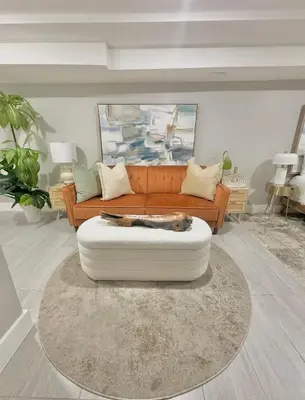 a living room with a couch with a dog laying on a rug at Large 4 Bedroom NYC Property in Mott Haven