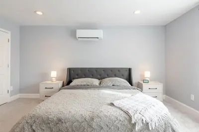 a white bedroom with a large bed with two night stands at Lakeview Family Retreat Newly Renovated 4BR House in Pocono Country Place