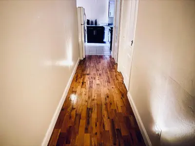 a hallway with a hard wood floor and a refrigerator at Modern Luxury Executive Room with NYC Fast Access in Paterson
