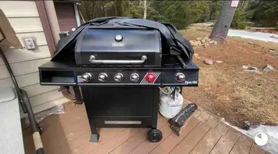 a grill on a porch with a dog under it at 6bds|Secluded|Pool|Hot tub|Sauna|Games|Movie in Long Pond