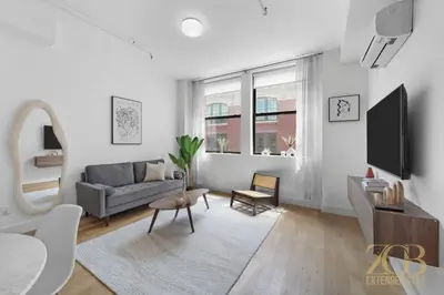 a living room with a couch and a tv at 517 - 47C Beautifully Renovated 1 bedroom in Prime Manhattan in New York