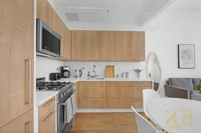 a kitchen with wooden cabinets and a stove top oven at 517 - 47C Beautifully Renovated 1 bedroom in Prime Manhattan in New York