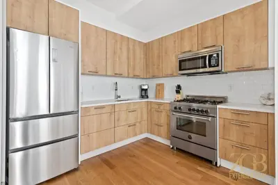 a kitchen with wooden cabinets and a stainless steel refrigerator at 517 -41D Gorgeous and Fully Equipped Luxury 1 Bedroom Apt in New York