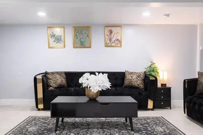 a living room with a black couch and a table at Modern Newark 1BR Apartment, Near Penn Station and EWR in Newark
