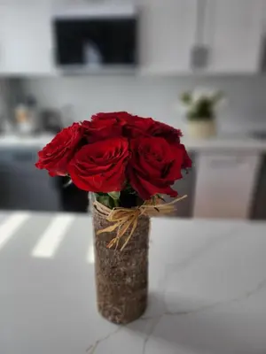 a vase filled with red roses sitting on a counter at Luxury Floral Loft with Balcony Near MetLife & NYC in Bogota
