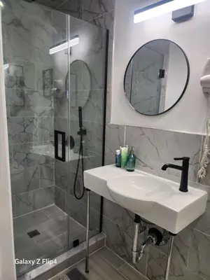 a bathroom with a sink and a shower at Luxury Floral Loft with Balcony Near MetLife & NYC in Bogota