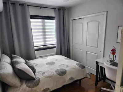 a small bedroom with a bed and a window at Luxury Floral Loft with Balcony Near MetLife & NYC in Bogota