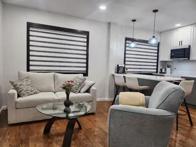 a living room with a couch and chairs and a table at Luxury Floral Loft with Balcony Near MetLife & NYC in Bogota