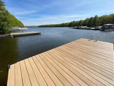 a wooden dock on a lake with boats in the water at Lakefront Paradise near everything! in Hawley
