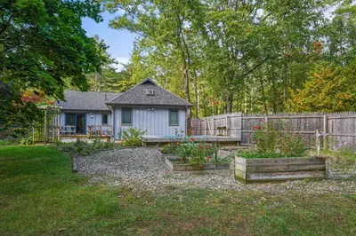 a house with a fence and some plants in a yard at 8 Mi to Saratoga Race Course Quiet Family Home in Saratoga Springs