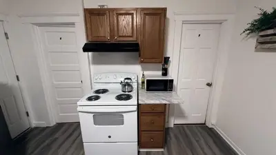 a kitchen with a white stove and wooden cabinets at Nona - Private Room 1 with Parking, Desk & Fast WiFi near Yale, Quinnipiac, SCSU & Hospitals in Hamden