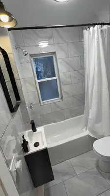 a bathroom with a tub and a toilet and a window at Nona - Private Room 1 with Parking, Desk & Fast WiFi near Yale, Quinnipiac, SCSU & Hospitals in Hamden