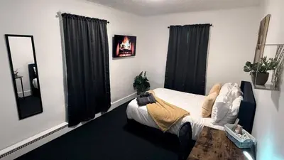 a bedroom with a bed with black curtains and a table at Nona - Private Room 2 with Parking, Desk & Fast WiFi near Yale, Quinnipiac, SCSU & Hospitals in Hamden