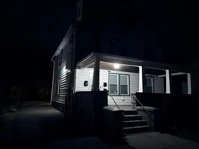 a house with a light on the front of it at night at Nona - Private Room 2 with Parking, Desk & Fast WiFi near Yale, Quinnipiac, SCSU & Hospitals in Hamden