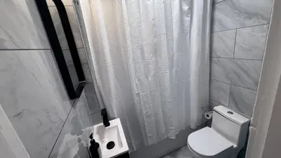 a bathroom with a white shower curtain and a toilet at Nona - Private Room 2 with Parking, Desk & Fast WiFi near Yale, Quinnipiac, SCSU & Hospitals in Hamden