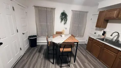 a kitchen with a wooden table and a sink at Nona - Private Room 3 with Parking, Desk & Fast WiFi near Yale, Quinnipiac, SCSU & Hospitals in Hamden