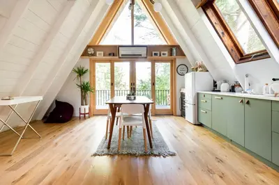 a kitchen with a table in the middle of a room at Modern A-Frame Cabin with Loft, Firepit and Grill in Catskill