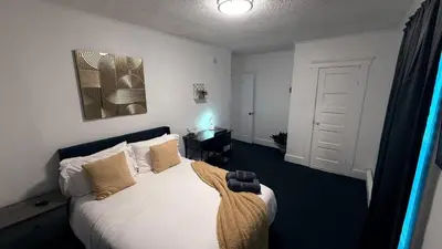 a bedroom with a bed with white sheets and pillows at Nona - Cozy 3BR Apt with Parking, Desk & Fast WiFi near Yale, Quinnipiac, SCSU & Hospitals in Hamden