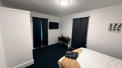 a hotel room with a bed and a television at Nona - Cozy 3BR Apt with Parking, Desk & Fast WiFi near Yale, Quinnipiac, SCSU & Hospitals in Hamden