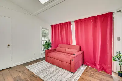 a red chair in a room with red curtains at 1 Mi to Connecticut River Home with Large Backyard in Glastonbury