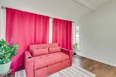 a red couch in a room with pink curtains at 1 Mi to Connecticut River Home with Large Backyard in Glastonbury