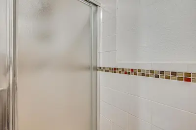 a shower with a glass door in a bathroom at 1 Mi to Connecticut River Home with Large Backyard in Glastonbury
