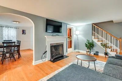 a living room with a fireplace and a table at 1 Mi to Connecticut River Home with Large Backyard in Glastonbury