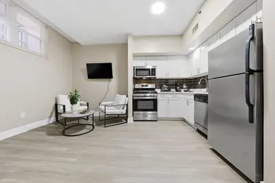 a kitchen with white cabinets and a refrigerator at Chic Studio Retreat in New Haven in New Haven