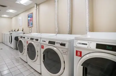 a laundry room with a row of washing machines at Chic Studio Retreat in New Haven in New Haven
