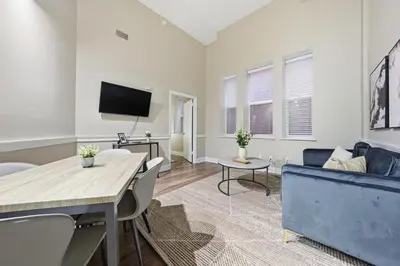 a living room with a blue couch and a tv at Modern 1BR perfect for extended visits in New Haven
