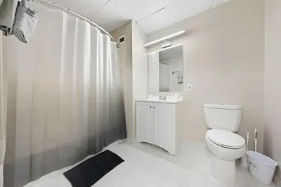a white bathroom with a toilet and a shower at Modern 1BR perfect for extended visits in New Haven