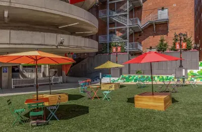 a group of tables and chairs with umbrellas on the grass at Modern 1BR perfect for extended visits in New Haven