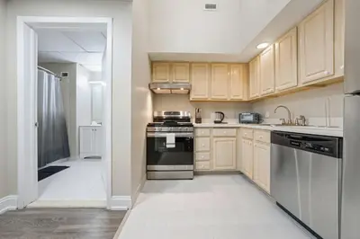 a kitchen with wooden cabinets and a stove top oven at Modern 1BR perfect for extended visits in New Haven