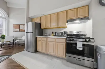 a kitchen with wooden cabinets and a stainless steel refrigerator at Relaxing studio perfect for extended visits in New Haven