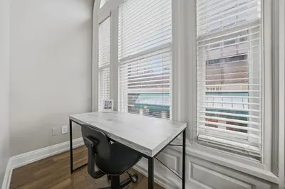 a desk in a room with two large windows at Relaxing studio perfect for extended visits in New Haven