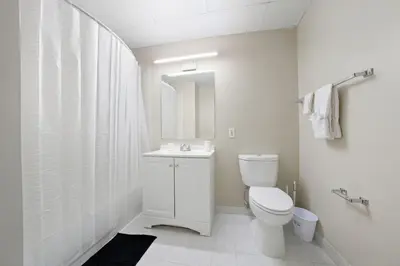 a white bathroom with a toilet and a sink at Relaxing studio perfect for extended visits in New Haven