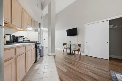 a kitchen with wooden cabinets and a table at Relaxing studio perfect for extended visits in New Haven