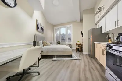 a large bedroom with a bed and a kitchen at Homey studio perfect for long-term guests in New Haven